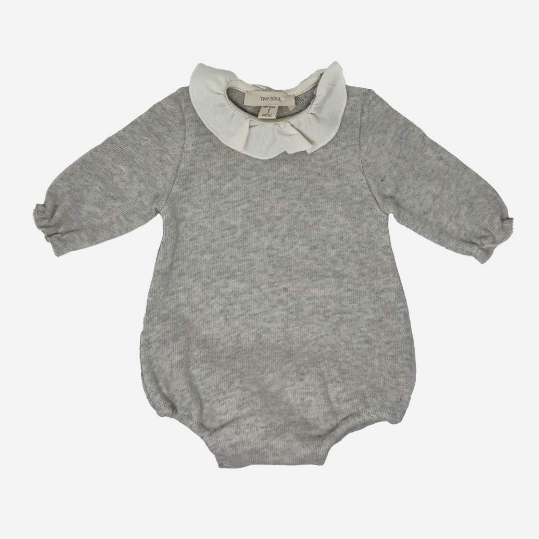 Sold at Bombon shop, designed by Tiny Soul — soft grey knit baby bodysuit with long sleeves and an ivory ruffled collar. front