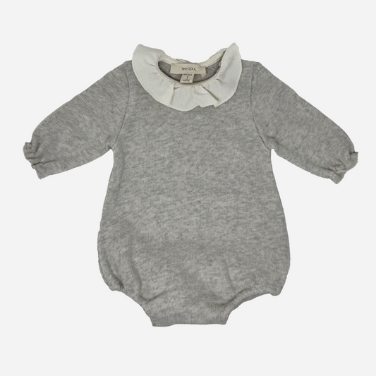 Sold at Bombon shop, designed by Tiny Soul — soft grey knit baby bodysuit with long sleeves and an ivory ruffled collar. front
