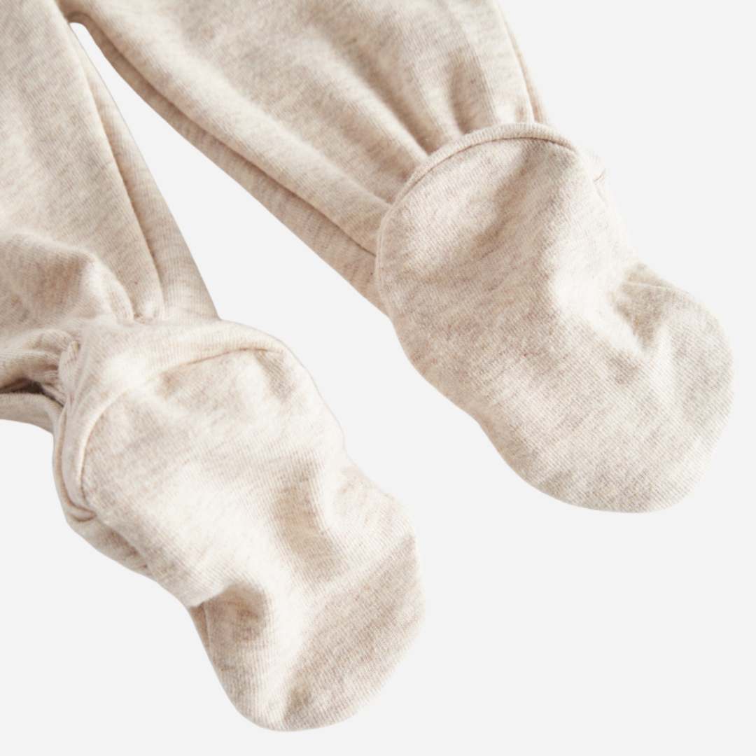 Sold at Bombon shop, designed by MarMar Copenhagen — beige organic cotton footed baby onesie with side tie closure.