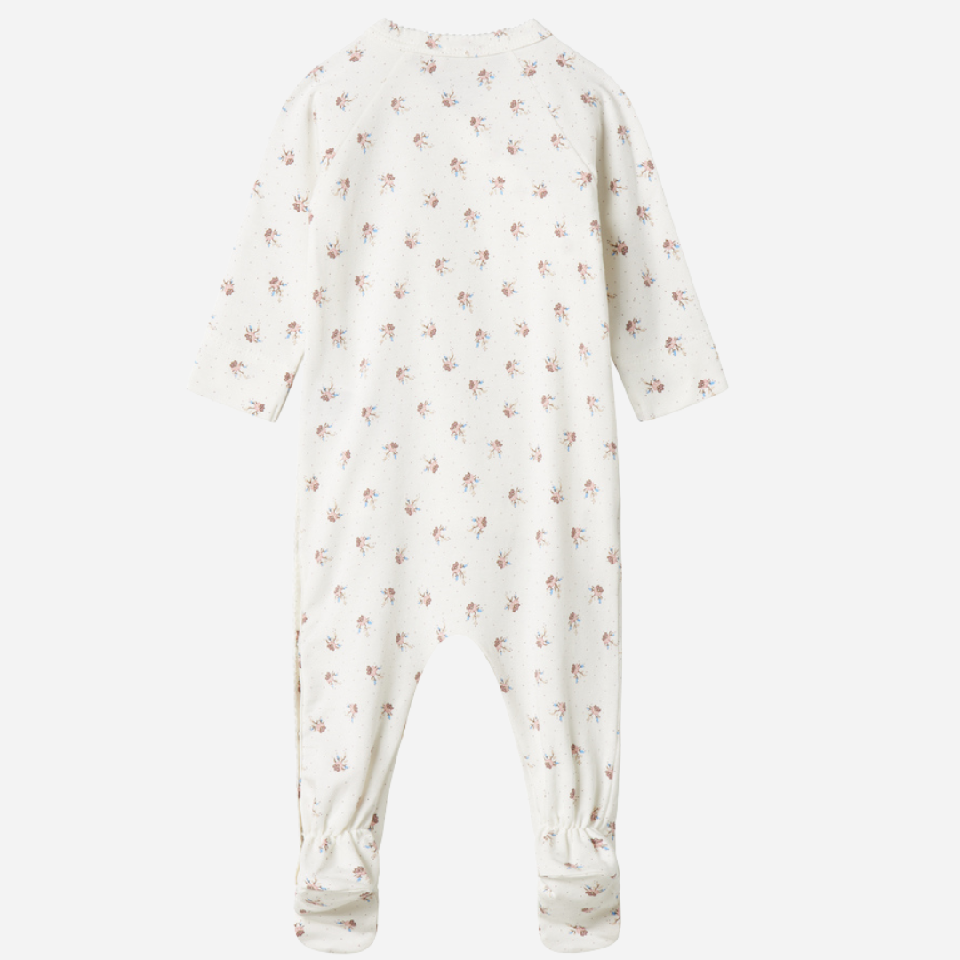 Sold at Bombon shop, designed by MarMar Copenhagen — white organic cotton baby onesie with floral print and side-tie closure, part of a matching set.