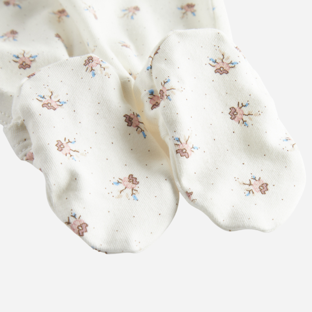 Sold at Bombon shop, designed by MarMar Copenhagen — white organic cotton baby onesie with floral print and side-tie closure, part of a matching set.
