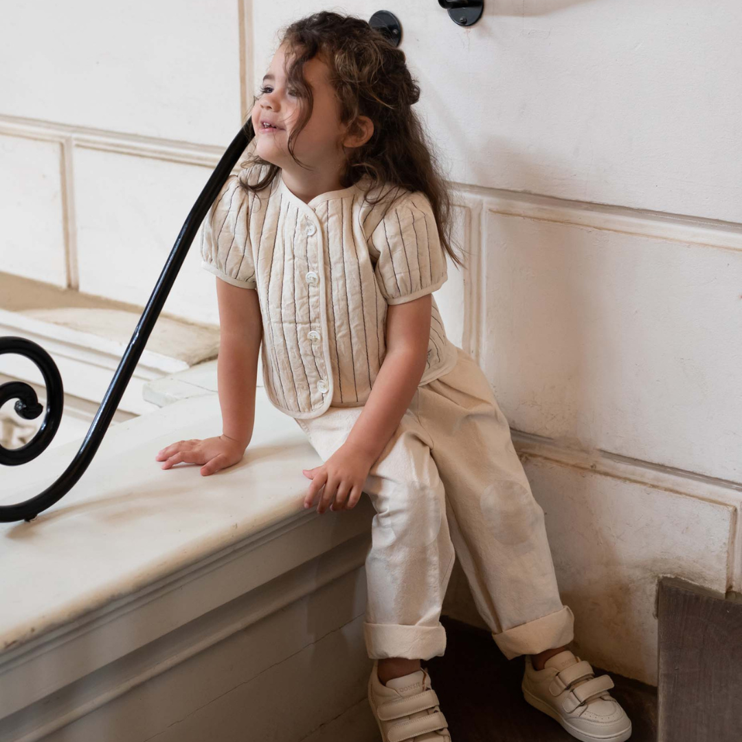 Sold at Bombon shop, designed by Donsje from Amsterdam, these baby and toddler trousers in warm white go with everything and are unisex. Perfect for pre fall all the way through winter.  model view