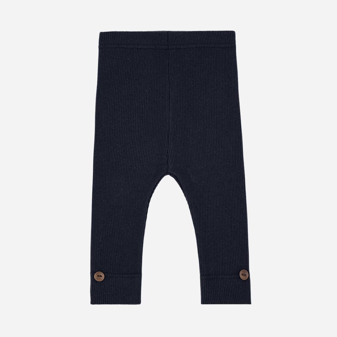 Sold at Bombon shop, designed by 1+ in the family — navy ribbed leggings with wooden button detail at ankle.