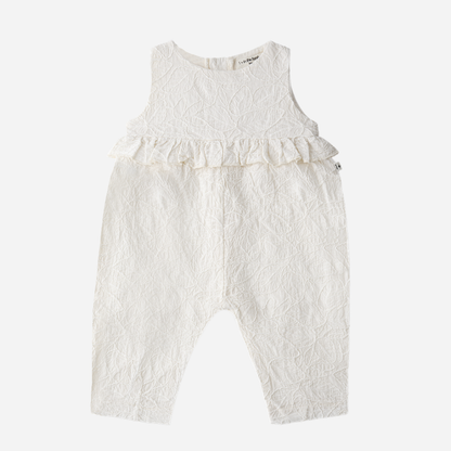 Sold at Bombon Shop, designed by 1+ in the family, off-white baby overall with textured cotton fabric and delicate ruffle detail across the chest.