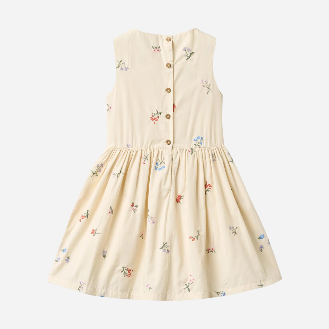 Sold at Bombon Shop, designed by Wheat, ivory organic cotton sleeveless dress with embroidered flowers and softly pleated skirt.