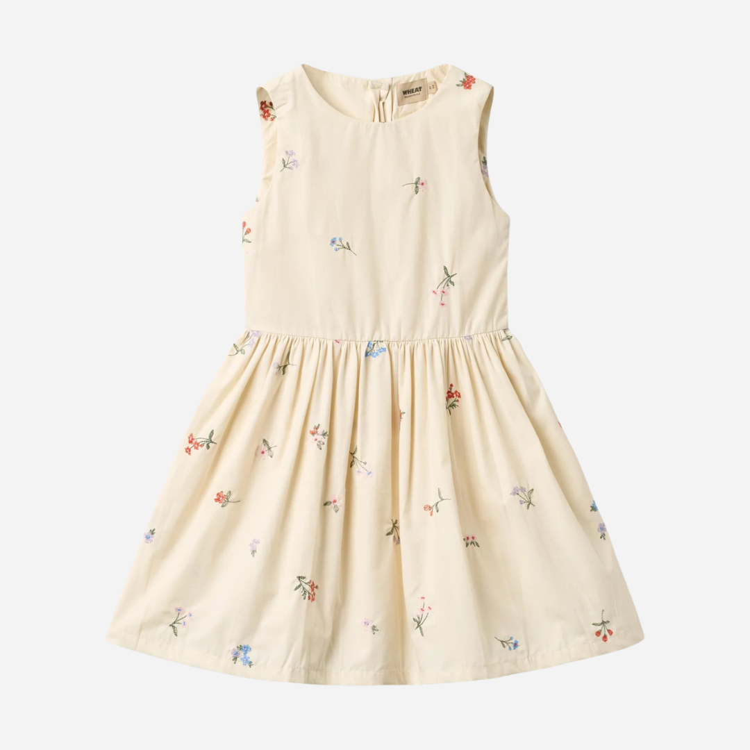 Sold at Bombon Shop, designed by Wheat, ivory organic cotton sleeveless dress with embroidered flowers and softly pleated skirt.