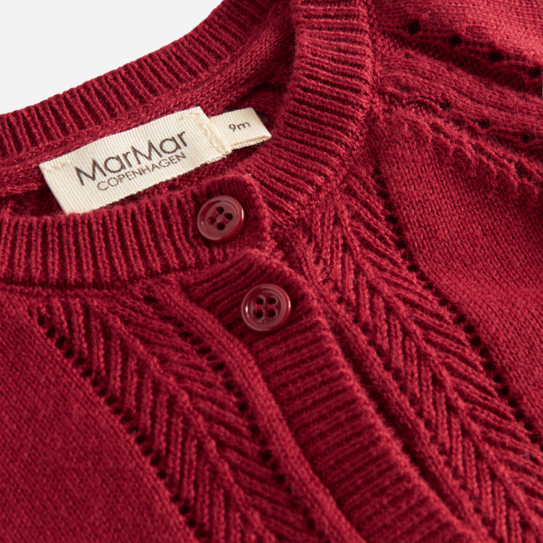 Sold at Bombon shop, designed by MarMar Copenhagen. Deep red knit baby cardigan with scalloped cuffs, pairs perfectly with the red plaid bloomers and embroidered collar bodysuit.