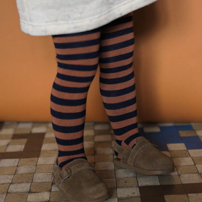 Sold at Bombon shop, designed by 1+ in the family — striped castagna and navy knit baby tights with feet.