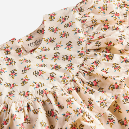 Sold at Bombon shop, designed by MarMar Copenhagen — floral cotton baby blouse with ruffled collar and hem, pairs perfectly with matching floral bloomers.