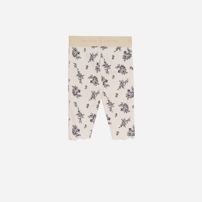 Sold at Bombon shop, these baby and toddler girl leggings by The New Society feature a soft cream base with an all-over floral print, a comfortable elastic waistband with logo detail, and a delicate lettuce-edge hem for a sweet everyday essential. back
