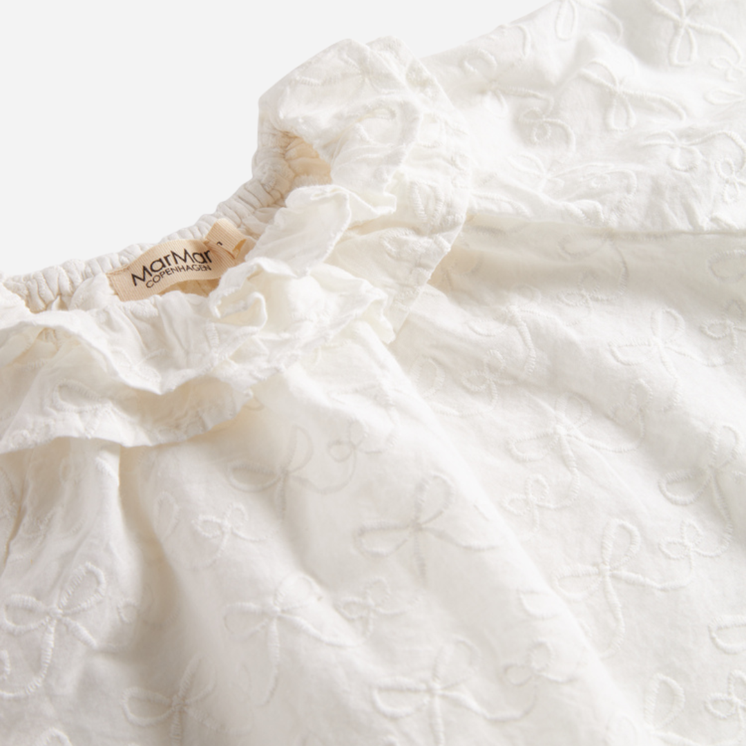 Sold at Bombon shop, designed by MarMar Copenhagen — cream 100% cotton baby blouse with ruffled collar and frilled cuff