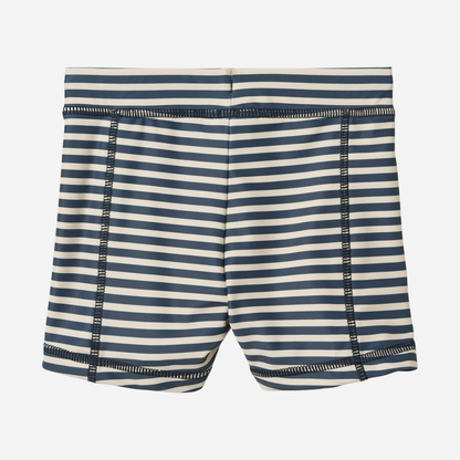 Sold at Bombon Shop, designed by Wheat, blue stripe swim shorts in recycled fabric with navy and light blue horizontal stripes and drawstring waistband.