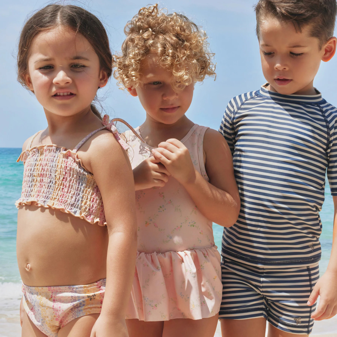 Sold at Bombon Shop, designed by Wheat, blue stripe swim shorts in recycled fabric with navy and light blue horizontal stripes and drawstring waistband.