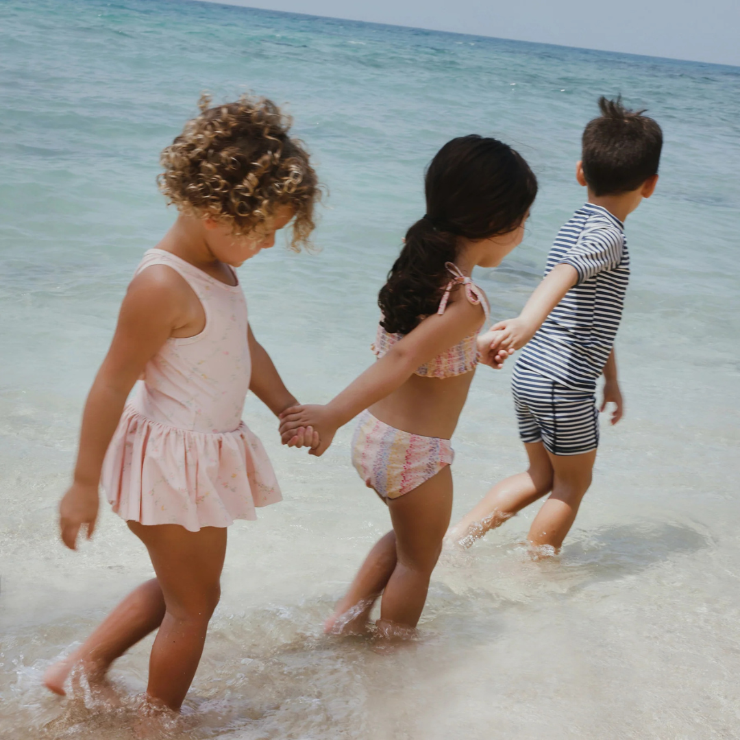 Sold at Bombon Shop, designed by Wheat, blue stripe swim shorts in recycled fabric with navy and light blue horizontal stripes and drawstring waistband.