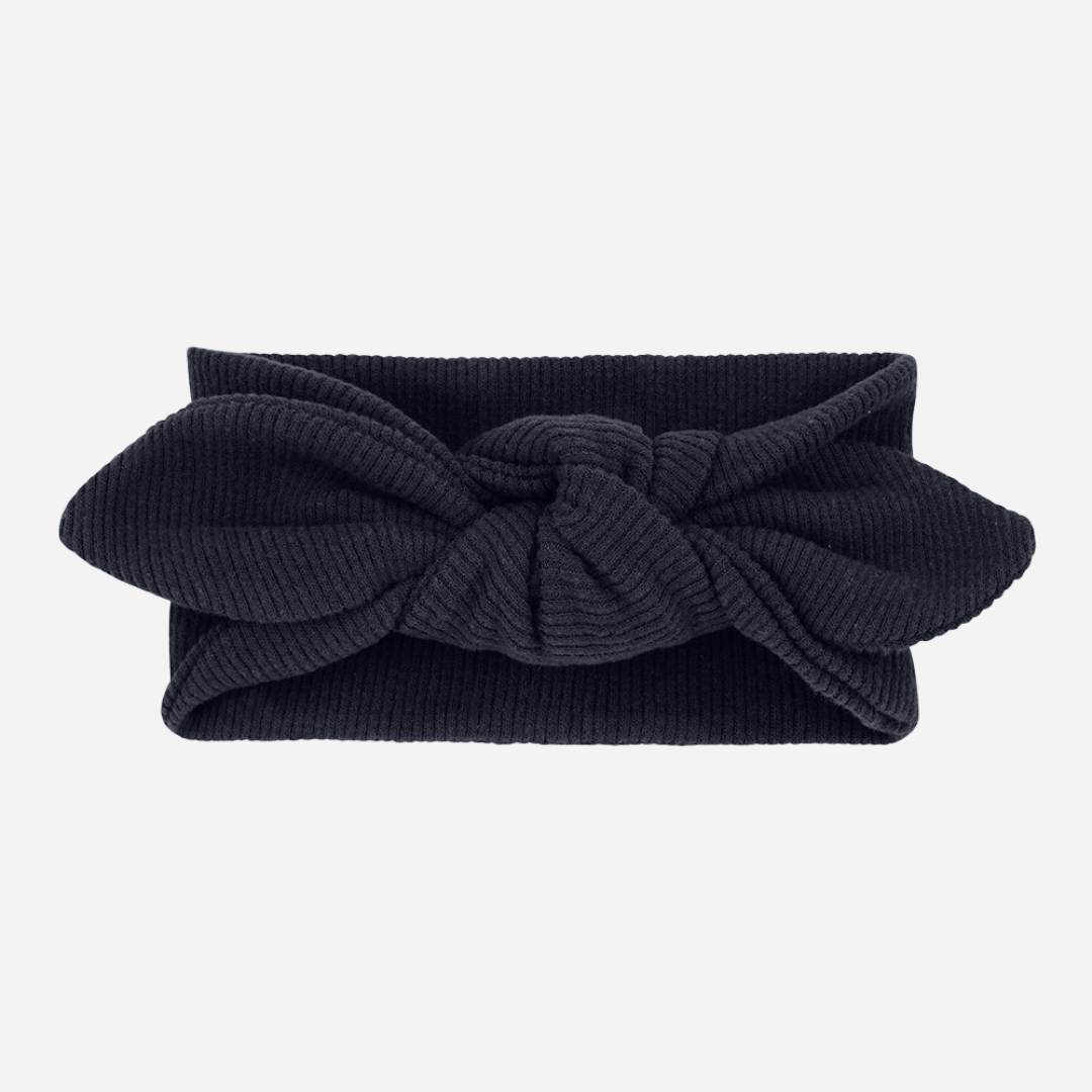 Sold at Bombon shop, designed by 1+ in the family – Ursula headband in navy blue with ribbed cotton texture and knotted bow detail.