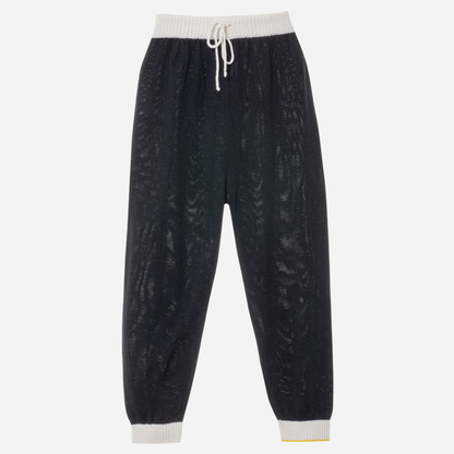 Sold at Bombon and designed by Gensami, navy blue knit baby pants with a white drawstring waistband, ribbed cuffs, and a yellow trim detail at the ankle.