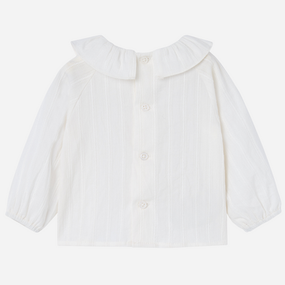 Sold at Bombon shop, designed by Paz Rodriguez, white baby blouse with ruffled collar and puffed sleeves.