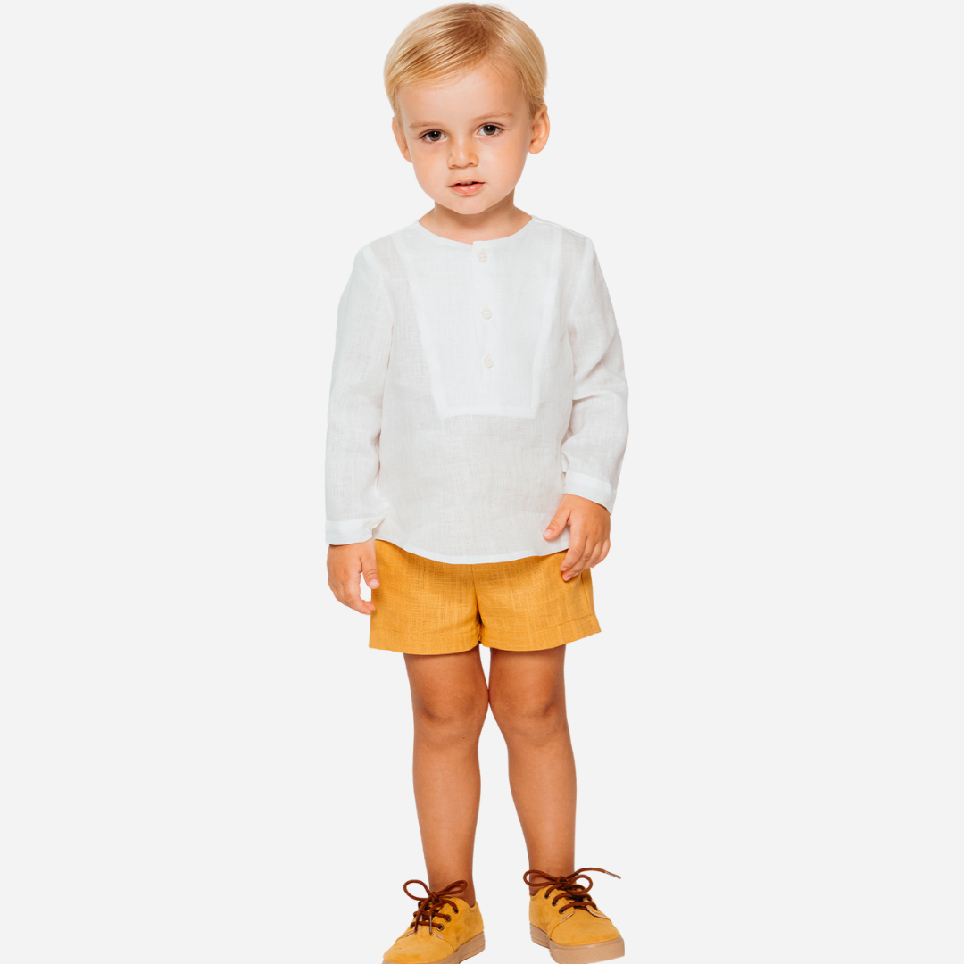 Sold at Bombon shop, designed by Fina Ejerique brand, white long sleeve bib shirt for babies and toddlers is perfect for spring and summer. Model view