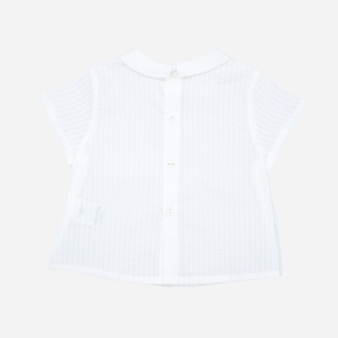 Sold at Bombon shop, designed by Fina Ejerique brand, white short sleeved baby shirt perfect for spring and summer. Back view. 