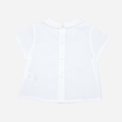 Sold at Bombon shop, designed by Fina Ejerique brand, white short sleeved baby shirt perfect for spring and summer. Back view. 