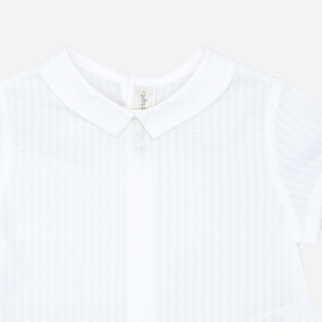 Sold at Bombon shop, designed by Fina Ejerique brand, white short sleeved baby shirt perfect for spring and summer. Zoom view