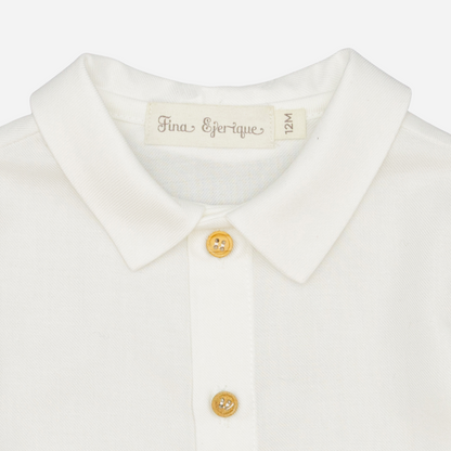 Sold at Bombon shop, designed by Fina Ejerique, a white viyella baby shirt with rounded collar, wooden buttons, and long sleeves. zoom
