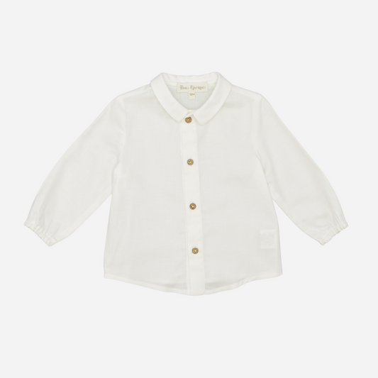 Sold at Bombon shop, designed by Fina Ejerique, a white viyella baby shirt with rounded collar, wooden buttons, and long sleeves. front
