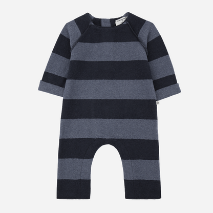 Sold at Bombon shop, designed by 1+ in the family – navy and grey striped baby jumpsuit with long sleeves and soft fabric, shown flat on white background front