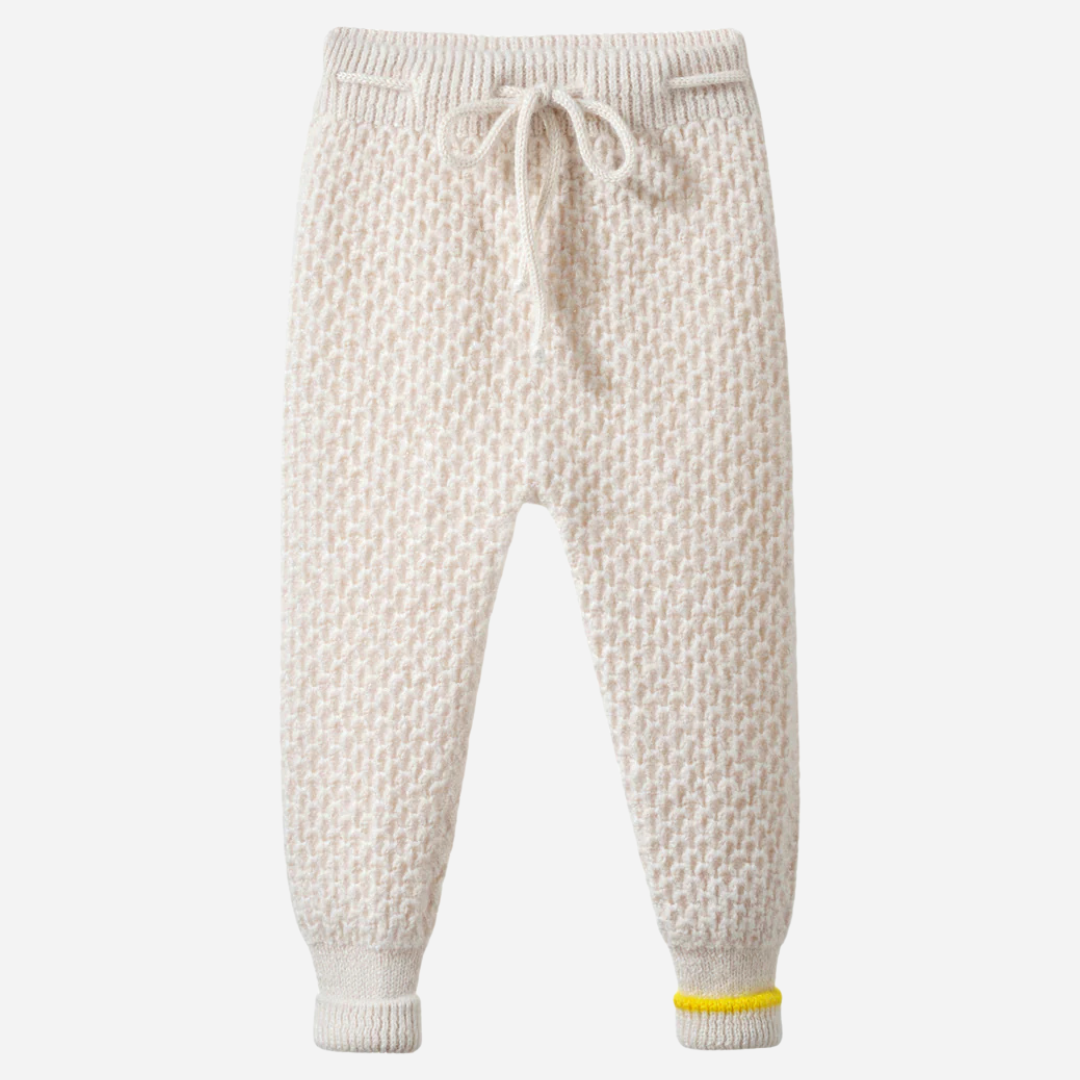 Sold at Bombon and designed by Gensami, a baby knit set including an ivory sweater with blue textured sleeves and matching ivory pants, both detailed with yellow trim accents.