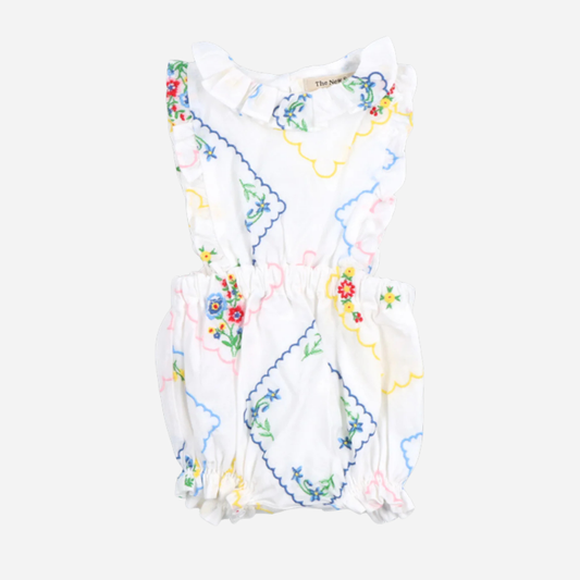 sold at Bombon, designed by The New Society baby romper with multicolor floral embroidery on soft cotton with ruffle details matching sibling set