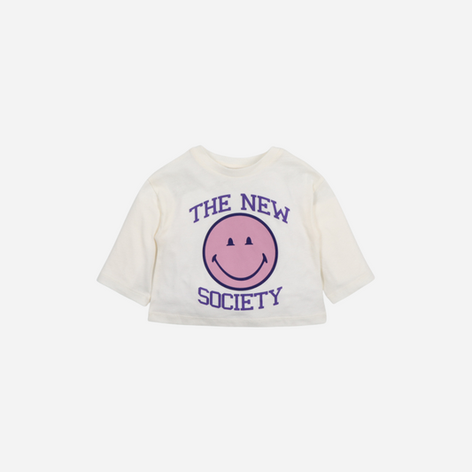 Sold at Bombon shop, this baby girl sweatshirt by The New Society features a cream base with a bold pink smiley face graphic and purple “The New Society” lettering, combining cozy comfort with playful, modern style. front